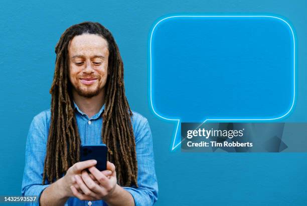 man using smart phone with neon  speech bubble - neon speech bubble stock-fotos und bilder