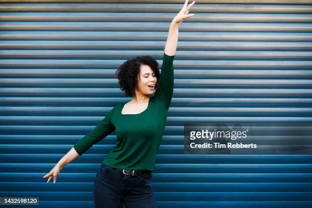 woman dancing, blue background - heldin stockfoto's en -beelden