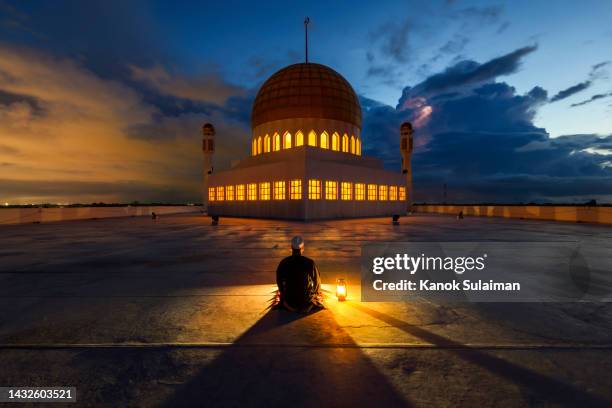 muslim man is praying on rooftop of  mosque at night - fasting activity foto e immagini stock