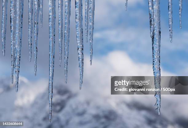 close-up of icicles hanging on frozen lake - つらら ストックフォトと画像