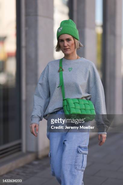Victoria Thomas seen wearing a Bottega Veneta green cassette leather bag,, Frankie Shop pants, a hernameis sweater and hernameis beanie on October...
