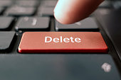 finger pressing red delete black keyboard button