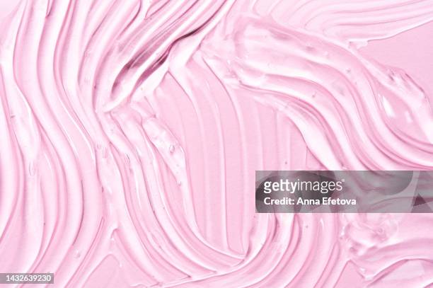 textured gel with air bubbles is smeared on pink background. concept of skincare and beauty. backdrop for your design. flat lay style. care cosmetics with peptides, ceramides, retinol molecules concept. oil or hyaluronic or polyglutamic acid - lubrication stock pictures, royalty-free photos & images
