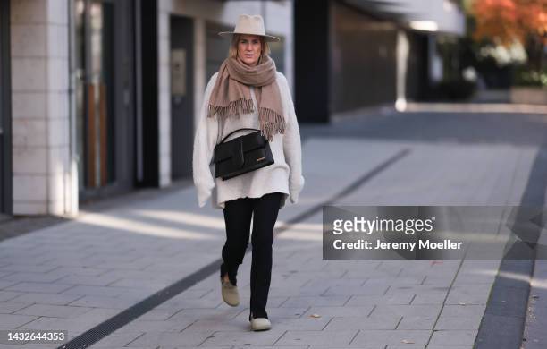 Victoria Thomas seen wearing Birkenstock shoes, H&M pants, a Black Palms sweater, an Acne Studios scarf, a beige hat and a Jacquemus black big bag on...