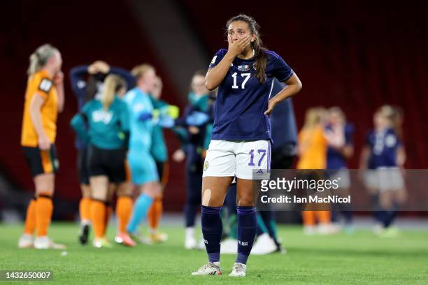 Abigail Harrison of Scotland looks dejected after the final whistle as players of Republic of Ireland celebrate after their victory secures...