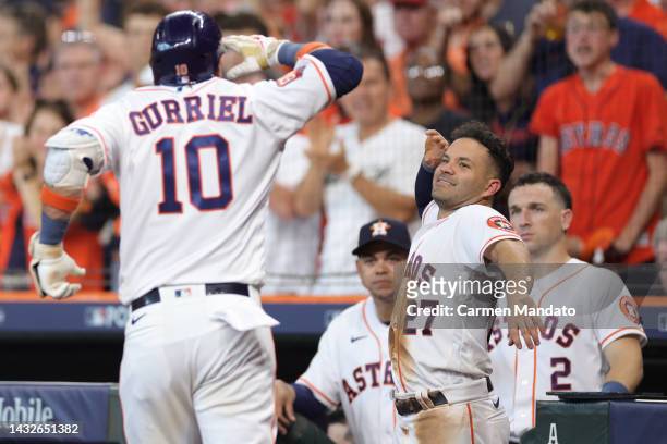 Jose Altuve of the Houston Astros congratulates Yuli Gurriel after his solo home run against the Seattle Mariners during the fourth inning in game...