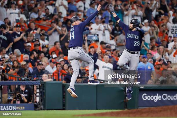 Eugenio Suarez of the Seattle Mariners is congratulated after his solo home run against the Houston Astros by third base coach Manny Acta during the...