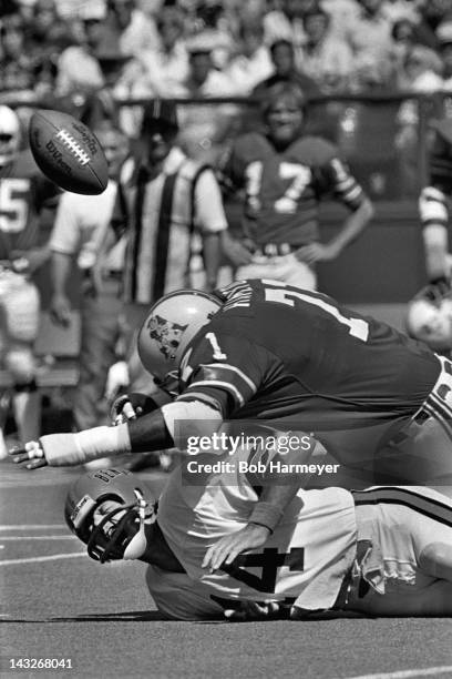 Quarterback Ken Anderson of the Cincinnati Bengals grimaces as he is sacked and fumbles the ball against Ray Hamilton of the New England Patriots on...