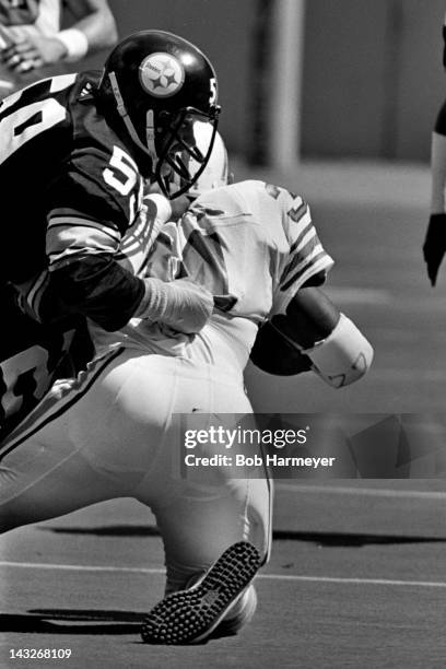 Running back Earl Campbell of the Houston Oilers is tackled by linebacker Jack Ham of the Pittsburgh Steelers on September 7 at Three Rivers Stadium...