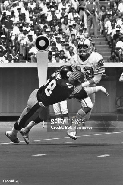 Linebacker Jack Lambert of the Pittsburgh Steelers tackles wide receiver Mike Renfro of the Houston OIlers on September 7 at Three Rivers Stadium in...