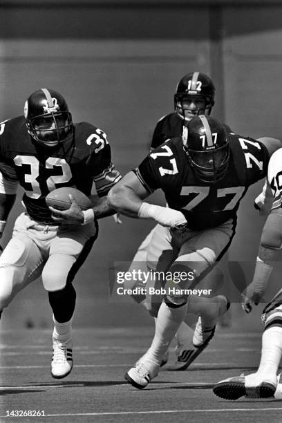 Fullback Franco Harris of the Pittsburgh Steelers carries the ball behind lineman Steve Courson during their game against the Cincinnati Bengals on...