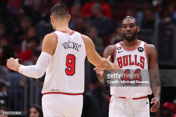 Nikola Vucevic and Patrick Williams of the Chicago Bulls high five against the Milwaukee Bucks during the first half of a preseason game at United...