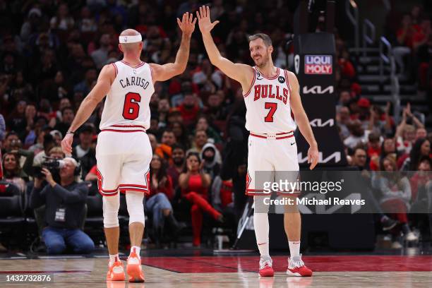 Alex Caruso and Goran Dragic of the Chicago Bulls celebrate a basket against the Milwaukee Bucks during the second half of a preseason game at United...