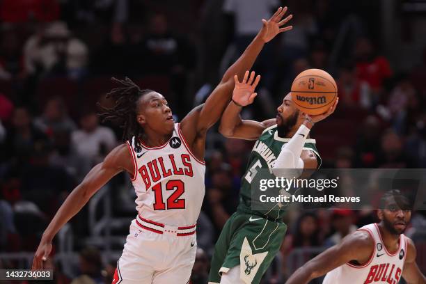 Ayo Dosunmu of the Chicago Bulls defends a shot by Jevon Carter of the Milwaukee Bucks during the second half of a preseason game at United Center on...