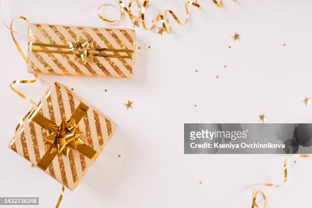 heap of gift or present boxes and stars confetti on white wooden table top view. flat lay composition for birthday, christmas or wedding. - christmas border stock pictures, royalty-free photos & images