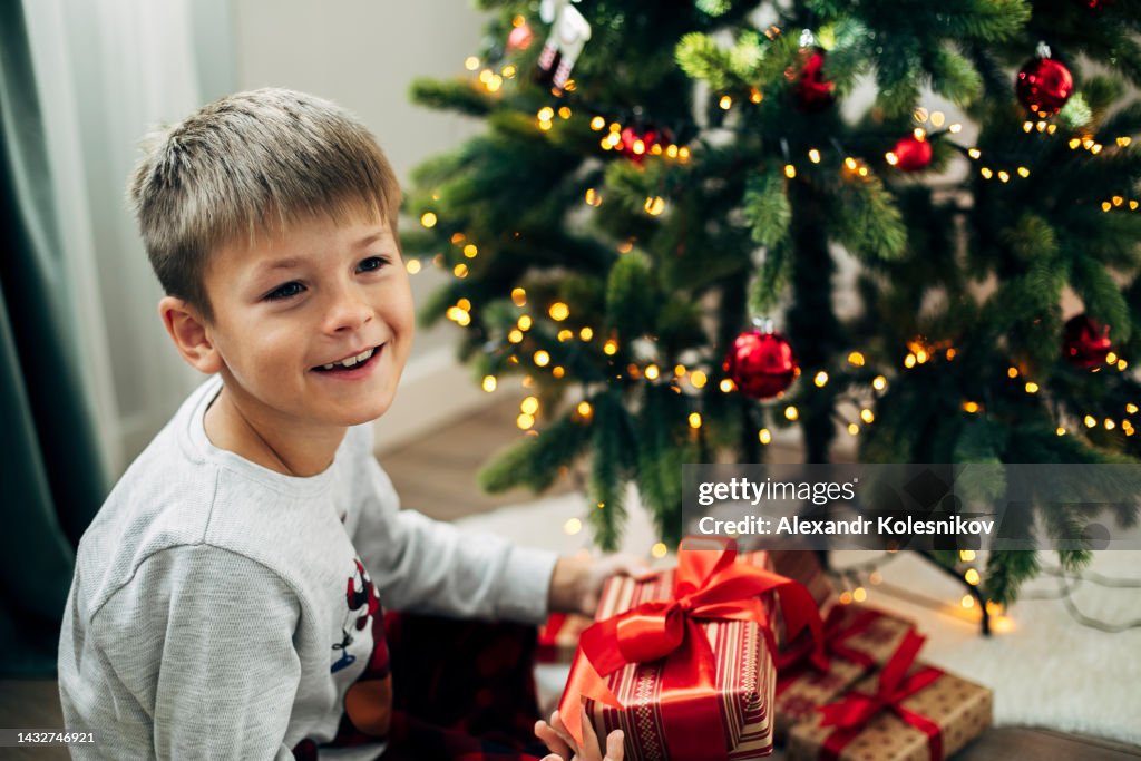 Happy boy 7-8 years old opening Christmas present