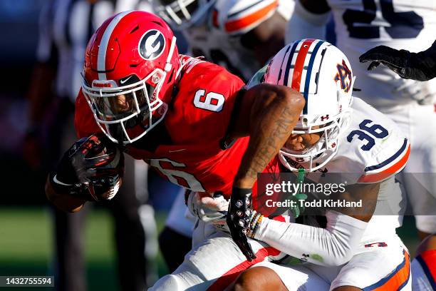 Kenny McIntosh of the Georgia Bulldogs is tackled by Jaylin Simpson of the Auburn Tigers in the second half at Sanford Stadium on October 8, 2022 in...