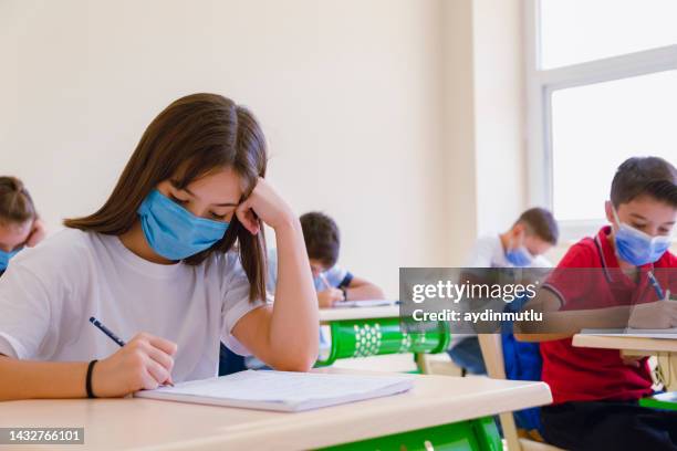 school boy studying in class with face mask during pandemic - epidemic school stock pictures, royalty-free photos & images