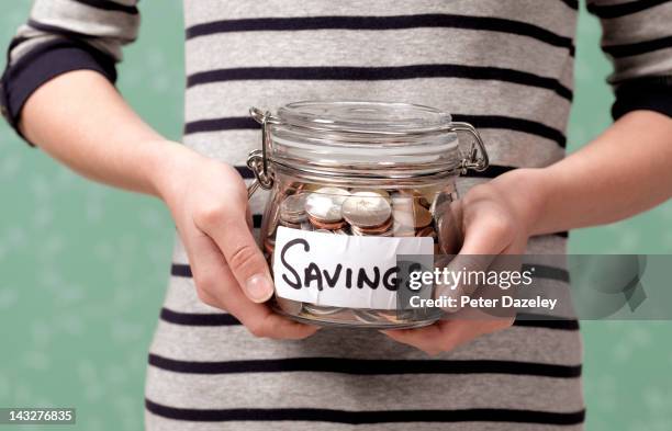 10 year old holding savings in jar - saving ストックフォトと画像