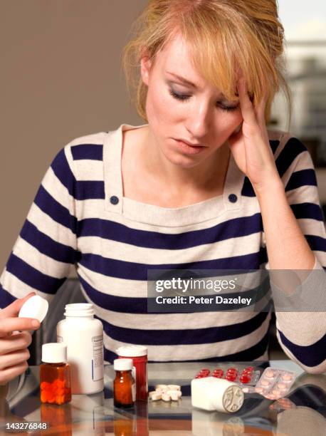 girl contemplating an array of perscription drugs - qual der wahl stock-fotos und bilder