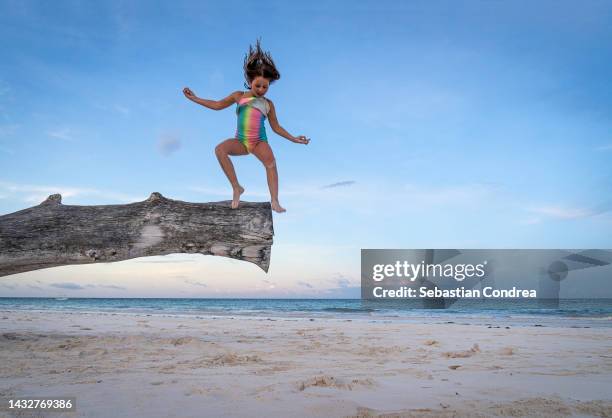 little girl doing a sensational jump on the beach, mombasa, kenya. africa - mombasa stock-fotos und bilder