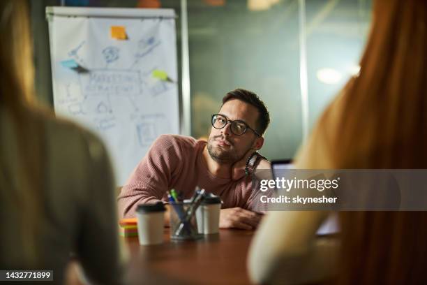 gelangweilter männlicher freelancer bei einem meeting mit seinen kollegen im büro. - langweilig stock-fotos und bilder