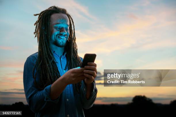 man using smart phone at sunset - smartphone lesen nacht stock-fotos und bilder