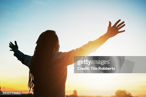 Man with arms outstretched at sunset