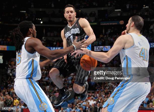 Redick of the Orlando Magic looses control of the ball against the defense of Kenneth Faried and Kosta Koufos of the Denver Nuggets at Pepsi Center...