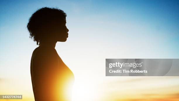 woman looking ahead at sunset - great expectations stock pictures, royalty-free photos & images