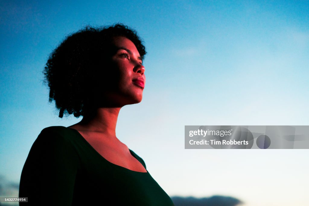 Woman looking up, illuminated