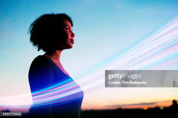 woman looking ahead with light streak - light trail stock-fotos und bilder