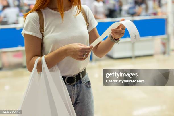 women shopping at the supermarket and looks at receipt total - total look stock pictures, royalty-free photos & images