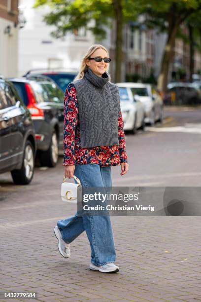 Sonja Leigh wears grey knit Sezane, floral print shirt, denim jeans Monki, bag Chloe, sneakers/ shoes New Balance, sunglasses NAKD & on October 11,...