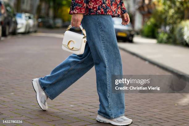 Sonja Leigh wears grey knit Sezane, floral print shirt, denim jeans Monki, bag Chloe, sneakers/ shoes New Balance, sunglasses NAKD & on October 11,...