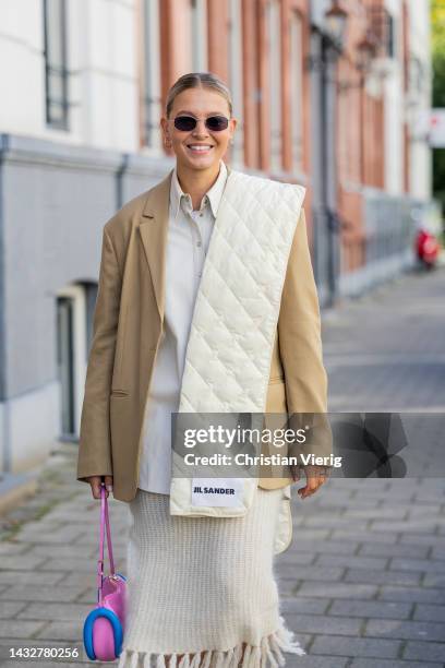 Hollie Mercedes Peters wears creme white fringed skirt H&M, black shoes Gucci Cara loafers, beige brown blazer Arket, latte puffer scarf Jil Sander,...