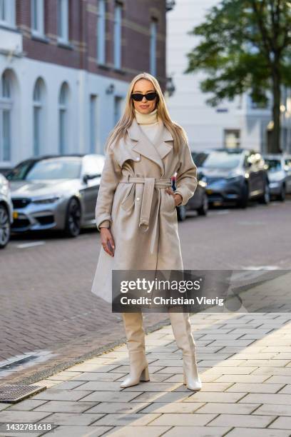ᐯeroni Leijnse wears knitted latte dress Zara, knee high boots Zara, belted beige coat Bash, sunglasses Celine on October 11, 2022 in Amsterdam,...