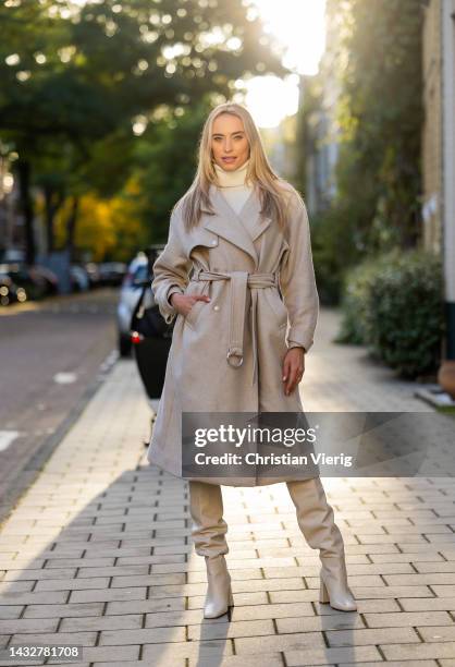 ᐯeroni Leijnse wears knitted latte dress Zara, knee high boots Zara, belted beige coat Bash on October 11, 2022 in Amsterdam, Netherlands.