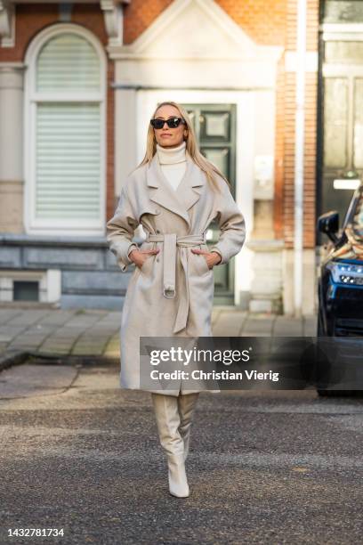 ᐯeroni Leijnse wears knitted latte dress Zara, knee high boots Zara, belted beige coat Bash, sunglasses Celine on October 11, 2022 in Amsterdam,...