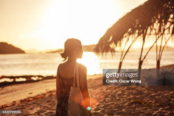 young asian woman watching sunset on the beach - beautiful filipino women stock pictures, royalty-free photos & images