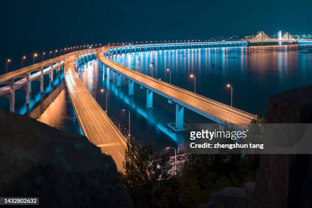 sea crossing bridge at night. - new bay bridge stock pictures, royalty-free photos & images