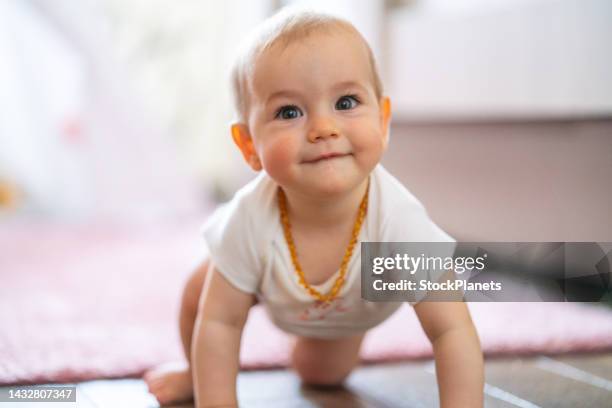 baby mädchen, das zu hause auf dem boden kriecht - baby cute stock-fotos und bilder