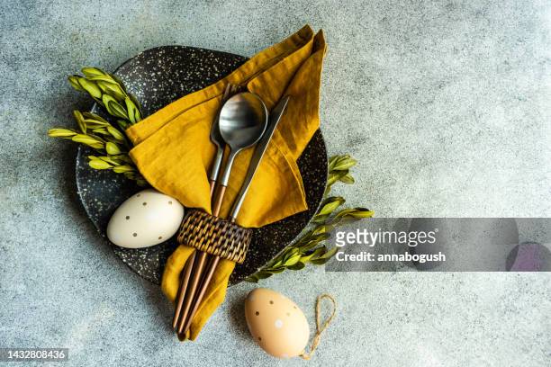 overhead view of an easter place setting on a table with painted easter eggs and foliage - napkin ring stock pictures, royalty-free photos & images