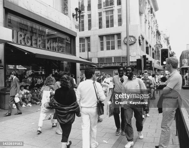 Shoppers and pedestrians passing a branch of 'Burger King' near the junction with Great Portland Street on Oxford Street, in the West End of London,...