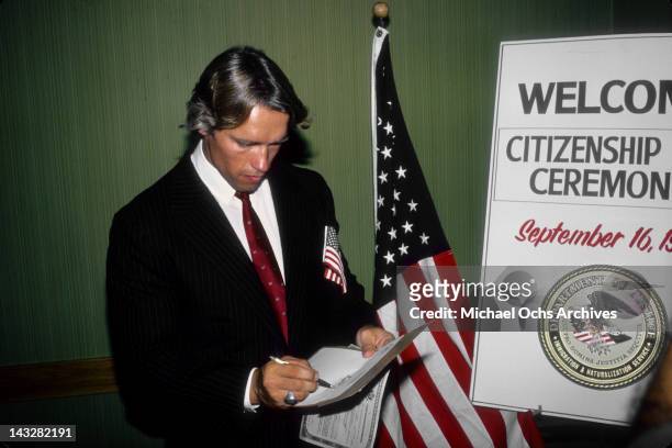 Austrian Bodybuilder and actor Arnold Schwarzenegger signs his paperwork as he becomes a U.S. Citizen on September 17, 1983 in Los Angeles,...