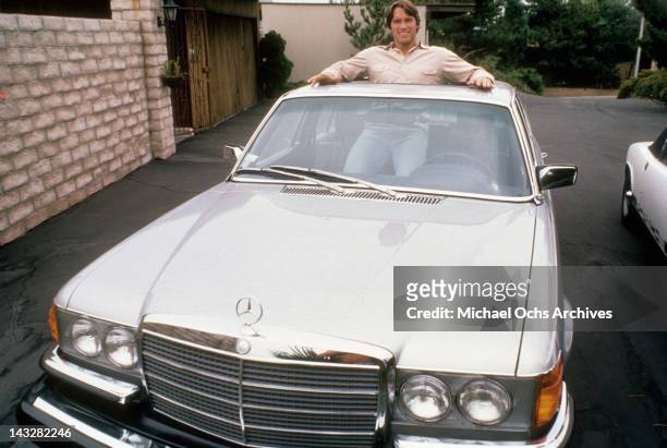 Austrian Bodybuilder Arnold Schwarzenegger poses for a photo standing in his Mercedes circa 1977 in Los Angeles, California.