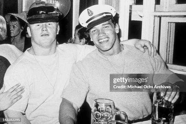 Young bodybuilder Arnold Schwarzenegger poses with a friend at Oktoberfest 1967 in Munich, West Germany.