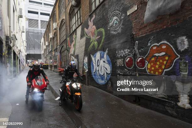 Jack Miller of Australia and Ducati Lenovo Team and Remy Gartner of Australia and Tech3 KTM Factory Racing ride the bikes along Duckboard Place to...