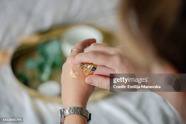 young woman applying make up foundation - foundation make up stock-fotos und bilder