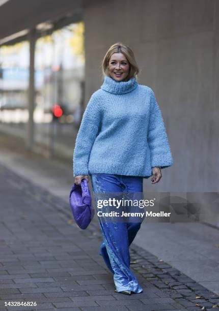Tanja Comba is seen wearing blue oversize turtleneck knit wool sweater from Christian Wijnants, blue velvet Balenciaga wide leg pants, purple leather...